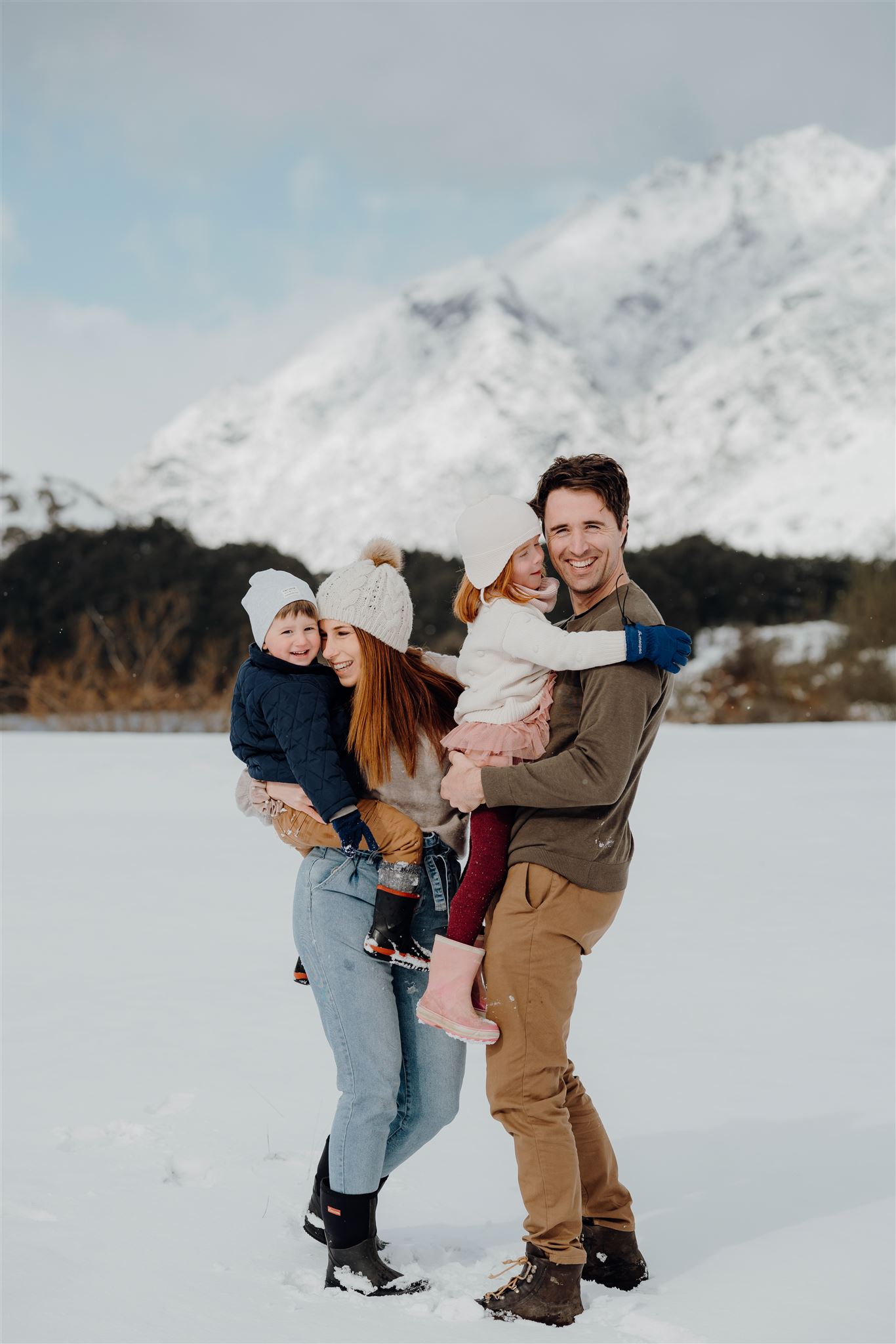 A family with two small children on holiday at Moke Lake in Queenstown being photographed during a family photoshoot by Haley Adele Photography a Waikato Photographer