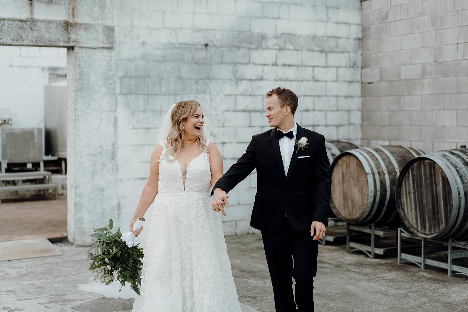 A bride and groom walking towards the photographer during a wedding photoshoot at Vilagrads Winery, being photographed by Haley Adele Photography
