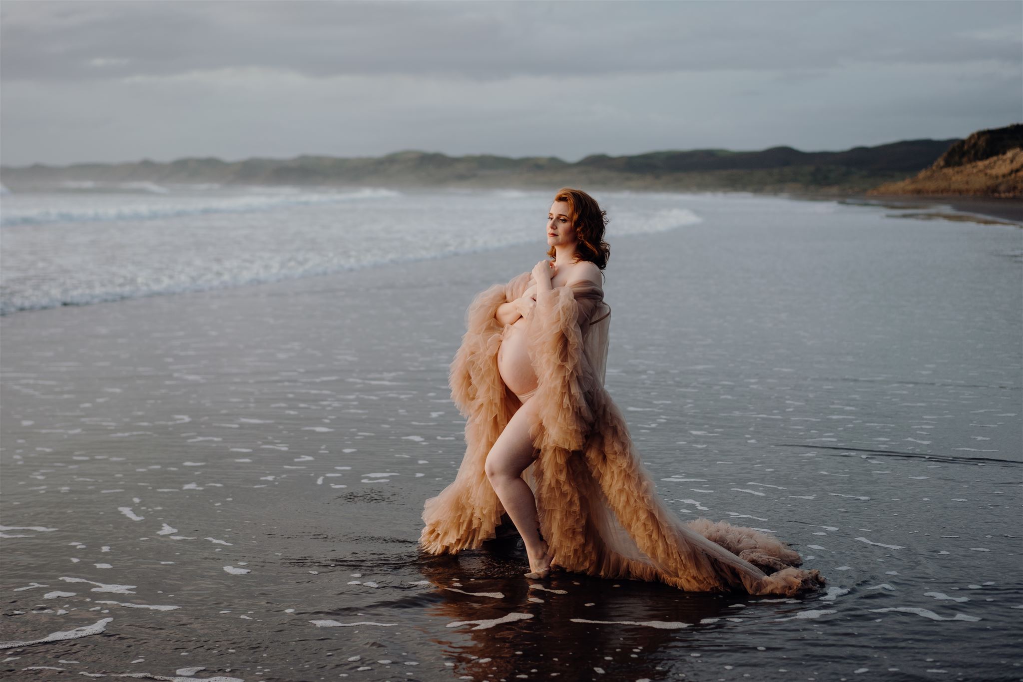 A pregnant woman being photographed on Ngarunui Beach in Waikato but Hamilton and Tauranga photographer Haley Adele Photography