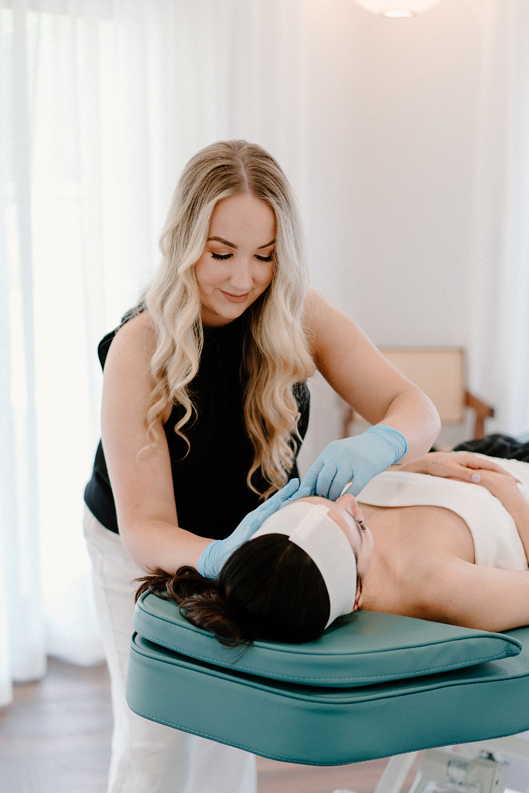 Tasmyn from Hideaway Boutique applying a product to a clients face during a beauty therapy service