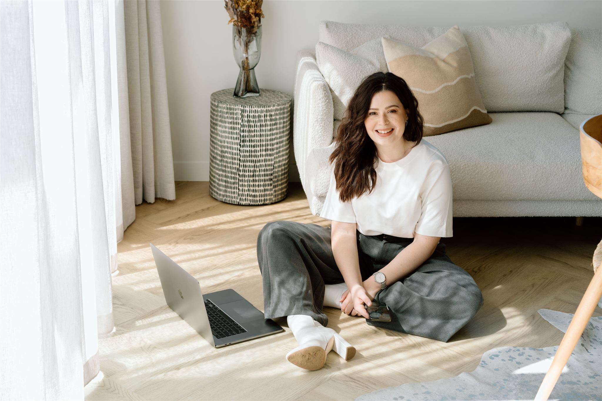 Kate from the curated now sitting on the floor in the morning light during her branding photoshoot with headshot photographer haley adele photography in waikato