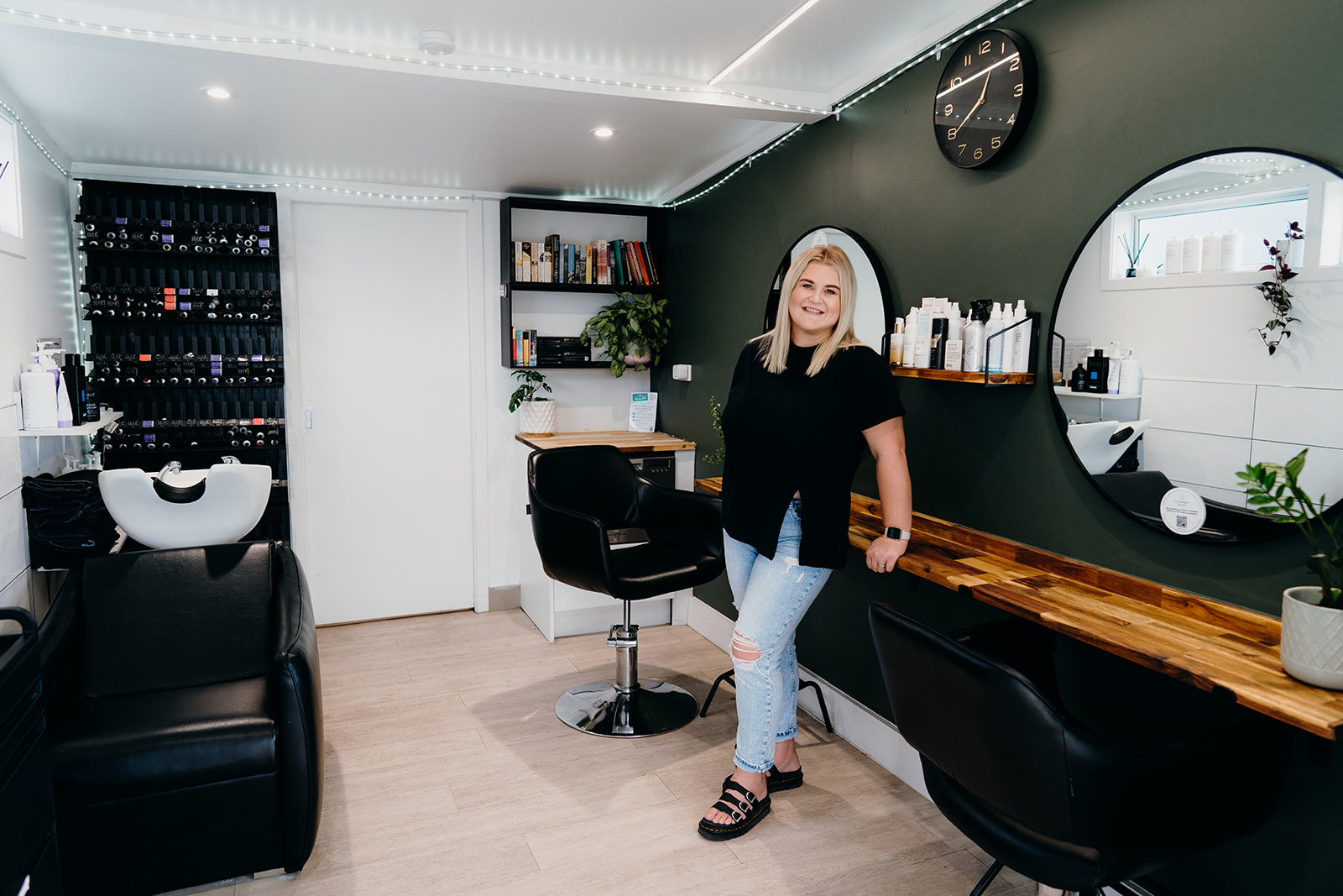 Liane from Mane and Co standing in her hair salon while haley adele photography photographs her during a commercial photoshoot