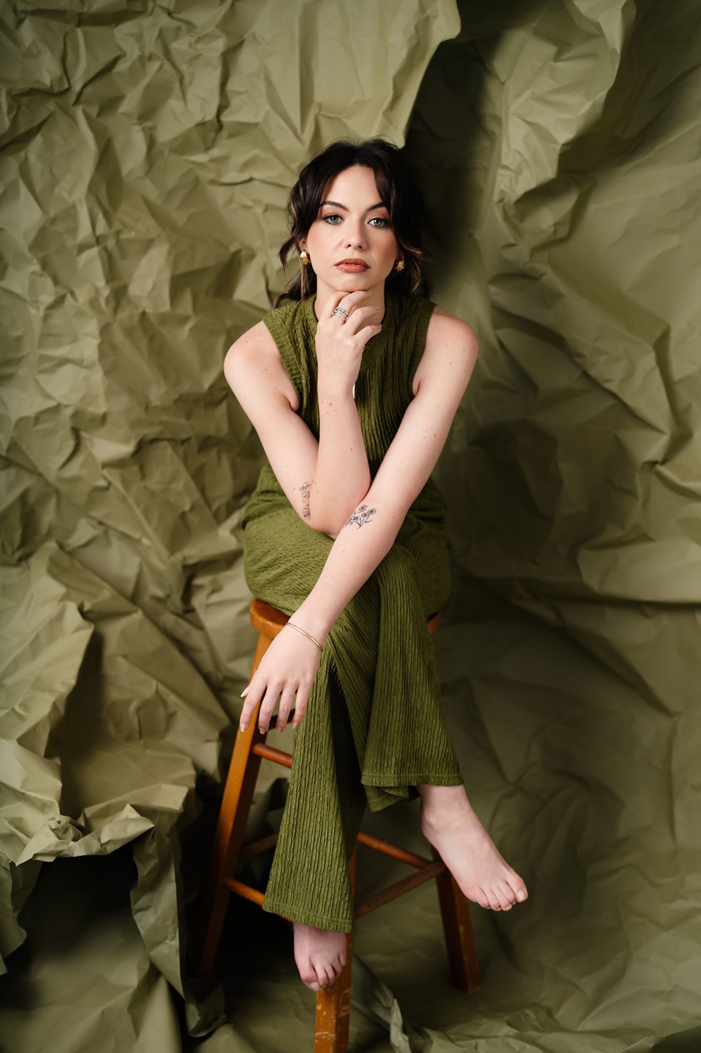 Kelsey photographed against a textured green set during a creative portrait photography session in Hamilton