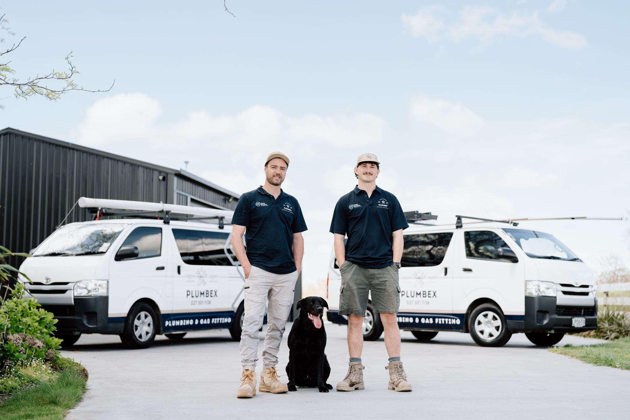 Plumbex team with their branded plumbing vans at their Hamilton premises during a commercial photography shoot
